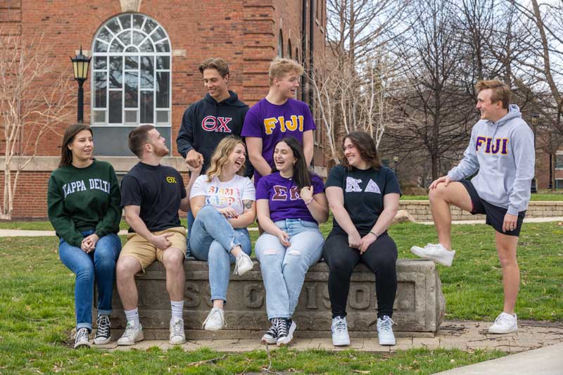 Greek life students at bench on quad