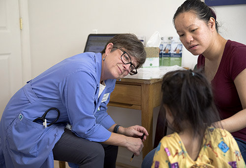 Mulberry speaks with a young patient at Mustard Seed Community Health. 