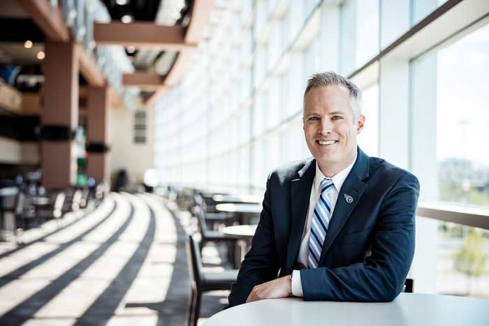 Burke Nihill ’00 sits for a photo inside Tennessee’s Nissan Stadium.