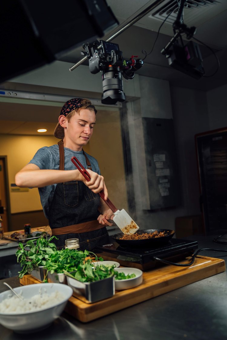 Elliott Notrica '26 sautees food at a cooking station