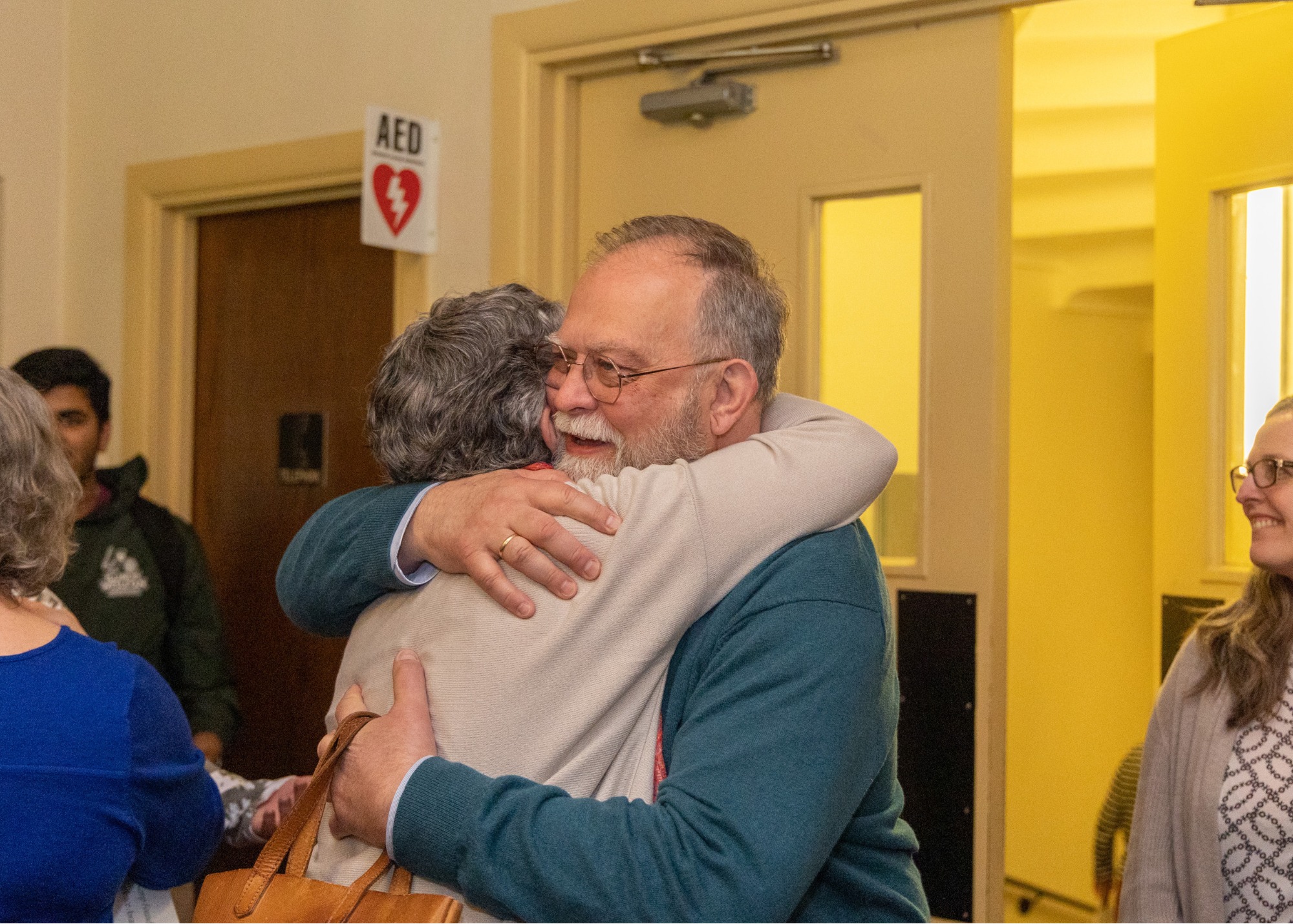 Curtis Trout embraces a colleague after receiving the Kemp Foundation Award