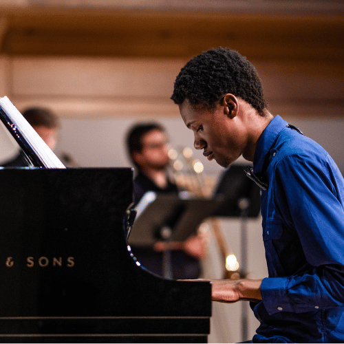 Student playing piano on stage at IWU