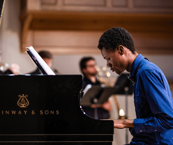 A student playing piano on stage at IWU