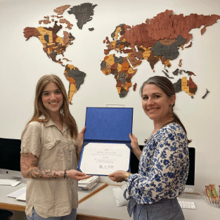 Zoe Hovde holding a certificate with Interim Provost and Dean of the Faculty Abbie Kerr