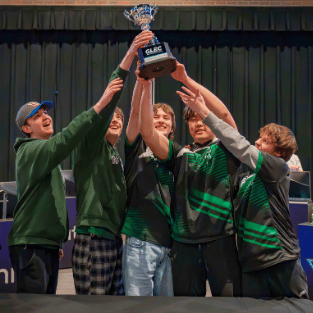 iwu esports students gathered and lifting up trophy