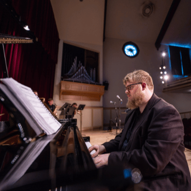 IWU student plays jazz at piano in Presser Hall