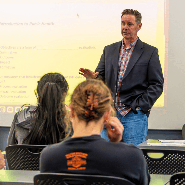 professor speaking in front of a public health classroom