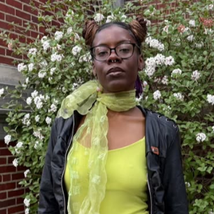 Chrishana Simon standing in front of IWU brick building