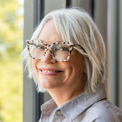 headshot of Stephanie Guedet in front of a sunlit window